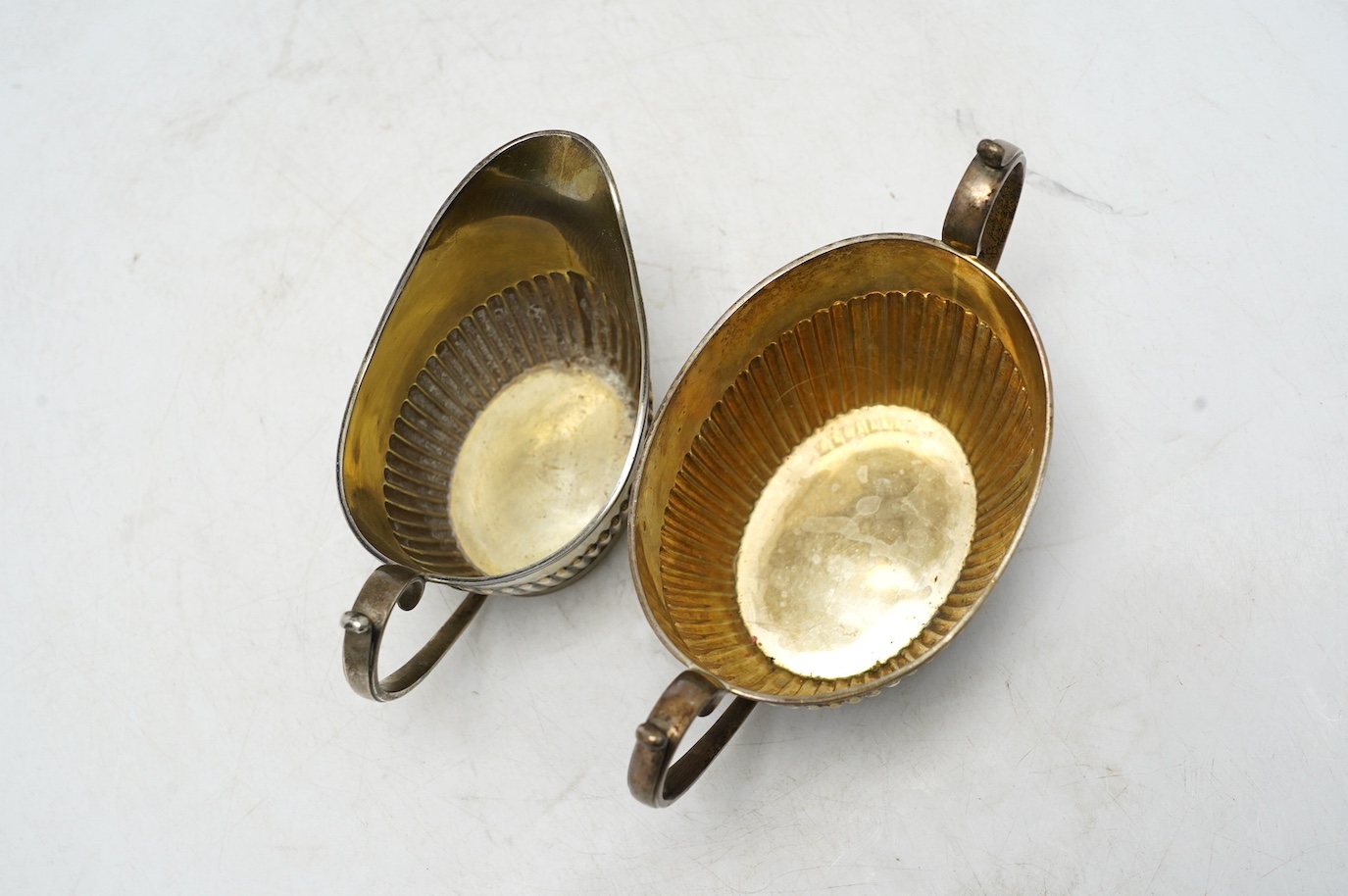 A late Victorian demi-fluted sugar bowl and cream jug, by Mappin & Webb, Sheffield, 1894, 8.6oz. Condition - fair